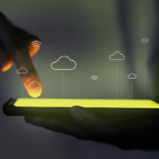 person håller mobil som lyser gult och projekterar moln hologram